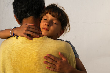 emotions in parent-child relationships. the girl in the arms of her father hugs him tightly