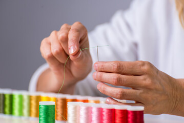 threads, threading the needle, many colors, dressmaker, atelier, sewing, sewing clothes, embroidering a fabric, selective focus