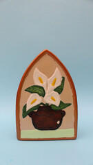 Flores de alcatraz pintadas sobre figura de cerámica