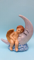Figura de cerámica con forma de ángel dormido sobre la luna 
