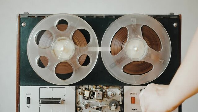 The girl turns on the old reel-to-reel tape recorder and playback is in progress