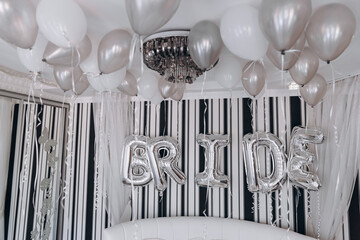 The room is decorated for the morning of the bride. Many inflatable balls, and balls with the...