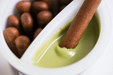 Close up of the chocolate biscuit stick dipping the green tea cream sauce