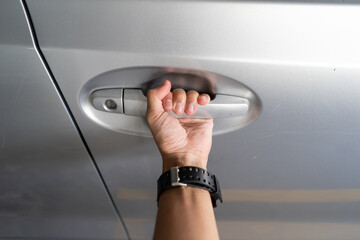 Hand holding the car door handle