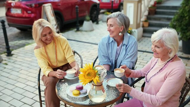 Happy group of senior women having a cappuccino in a cafe and spending good quality time together. Concept about lifestyle and seniority