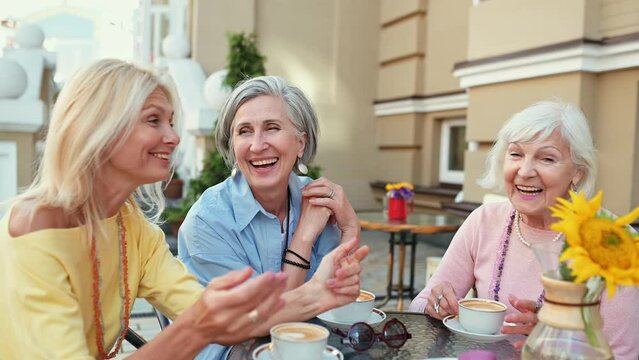 Happy group of senior women having a cappuccino in a cafe and spending good quality time together. Concept about lifestyle and seniority