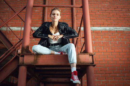 Beautiful girl on the stairs of a brick building.