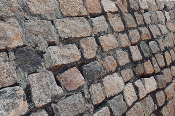 Stone wall texture background. Stone arrangement in pattern. Abandoned stone wall construction in the historical heritage site at shore temple complex at Mahabalipuram, Tamilnadu, India.
