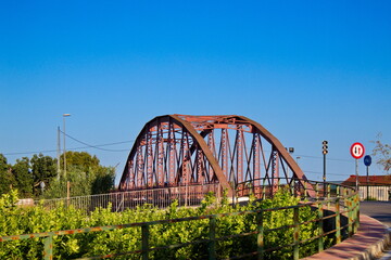 Nice landscape with an old metal bridge that crosses over the Segura River that carries water to irrigate the garden of Murcia