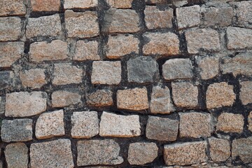 Stone wall texture background. Stone arrangement in pattern. Abandoned stone wall construction in...