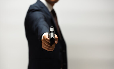 スーツ姿で拳銃を構える男性