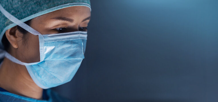 Diverse team of professional medical surgeons perform surgery in the operating room using high-tech equipment. Doctors work to save a patient in a modern hospital. Medicine, technology and healthcare.