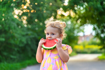 Child girl eats watermelon in summer. Selective focus.