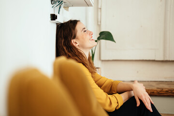 Young woman leaning against a wall and laughing