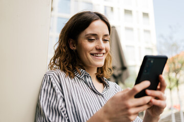 Young woman in the city looking at her cell phone