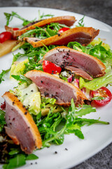 Salad with tuna, avocado, arugula greens, candied pear and cherry tomatoes
