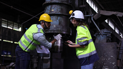 FemaFemale engineer with safety vest and hard hat work check in manufacturing , Female Industrial Specialist work with technician in a Metal Manufacture