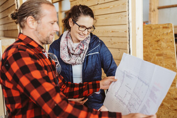 carpenter and customer looked at a construction plan - 524096338