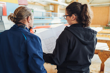 two carpenters looked at a construction plan