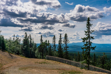 Summer mountain view landscape ski slope trail with trees and sky in the background in Vemdalen Sweden.