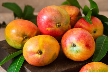 Naklejka na ściany i meble Fresh,ripe delicious mangoes on a wooden background.