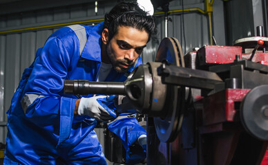 Adult handsome male mechanics wearing uniform, using machine for fix, repair car or automobile components, teamwork helping, working in car maintenance service center or shop. Industry Concept.