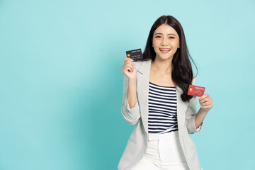 Happy young Asian businesswoman smiling and showing two credit card for paying online business...