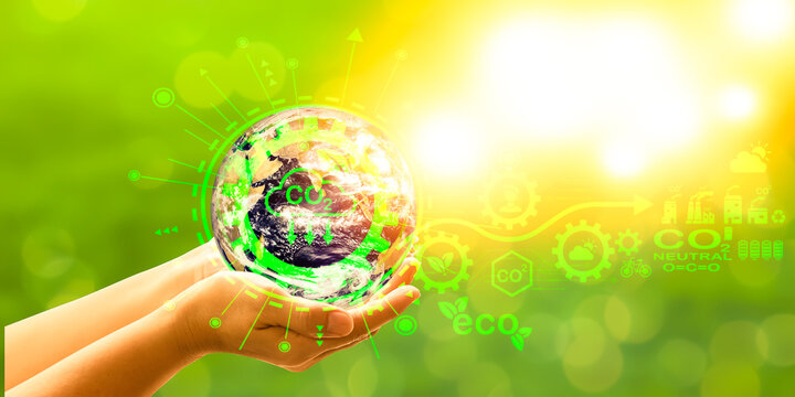 Female hand depicting a virtual diagram. Neutral target action on net zero emissions and carbon dioxide. Elements of this image are furnished by NASA. on a green background