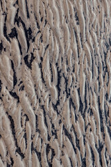 texture of sand, natural sand pattern on the beach. Sand surface with pattern, sand texture background