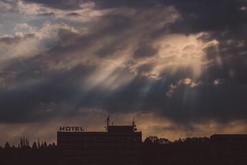 sunset over the city and sun rays over an old hotel