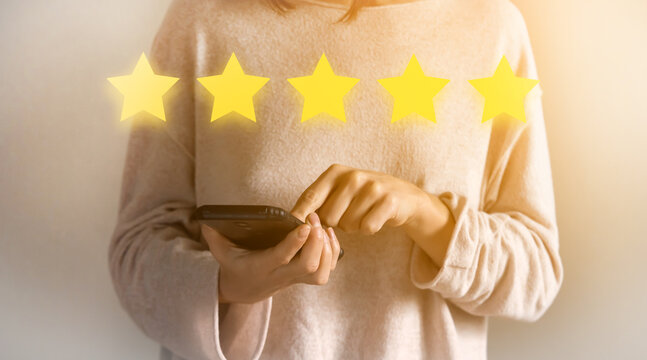 Girl is rating "five star" using a mobile phone.