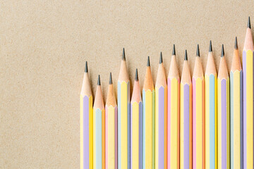 pencil on brown background,wooden pencil on brown paper,Several pencils on brown paper,top view of wooden brown pencil placed on brown paper for background