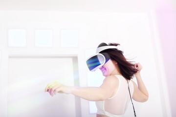 A beautiful slim brunette wearing a VR headset in a futuristic setting with flares