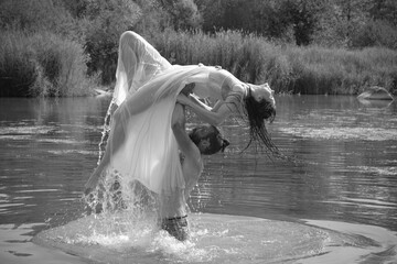 caucasian couple doing stunts in a lake