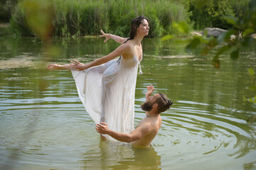 caucasian couple doing stunts in a lake