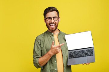 Happy middle aged man pointing at empty laptop screen with space for your design over yellow...