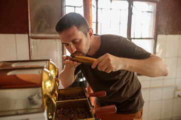 Q grader with closed eyes while enjoying the aroma of coffee beans at production