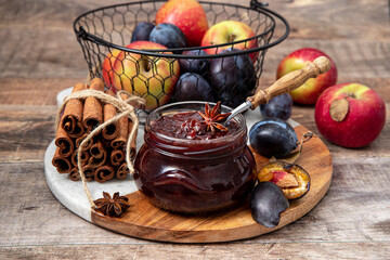 Homemade plum jam in a glass jar on a wooden background.Selective focus