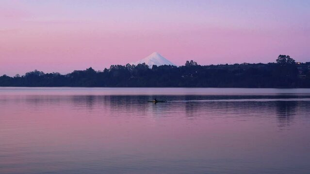 Kayak in lake llanquihue with volcano at sunset in puerto varas chile