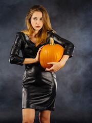 Beautiful young woman holding pumpkin for Halloween