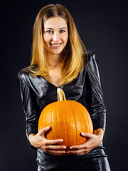 Stunning young woman holding pumpkin for Halloween
