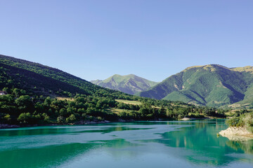 Naklejka na ściany i meble Panorama of the Fiastra Lake on the Sibillini Mountains in Marche with a bright blue sky. Italy