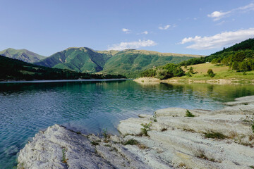 Panorama of the Fiastra Lake on the Sibillini Mountains in Marche with a bright blue sky. Italy