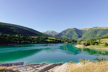 Panorama of the Fiastra Lake on the Sibillini Mountains in Marche with a bright blue sky. Italy