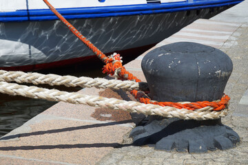 Bollard with ship's ropes on the background of the side of the ship.