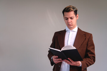 Concentrated businessman reading a book on a white background. Elegant man in a suit on an isolated white background.