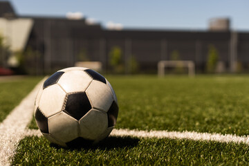 Fototapeta na wymiar white and black soccer ball on green grass and stadium background. sports betting idea.