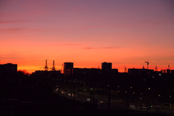 Bright dawn over the city, colorful sky over the houses early in the morning