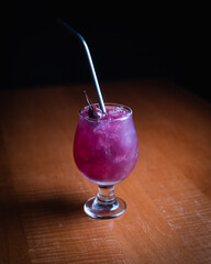 purple cocktail with cherry garnish 