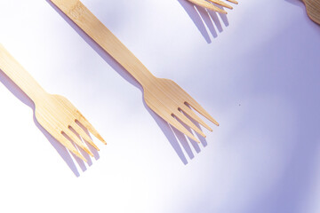 Wooden eco bamboo cutlery forks on bright white background. Meal time concept